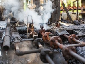 Close-up of a corroded gas pipe showing signs of rust and damage, highlighting the risk of gas leaks.