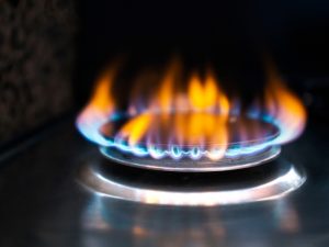 lose-up of a lit gas burner, emphasising the need for cleaning gas stove burners for efficient flame performance.