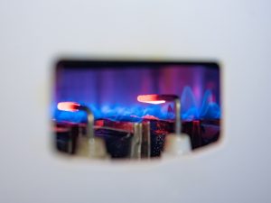 Close-up of a gas heater flame and igniter, representing common gas heater problems like ignition issues.