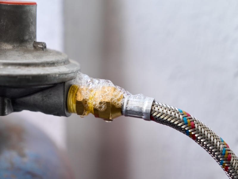 Bubbles forming on gas pipe joint showing how to detect gas leak in house visually.