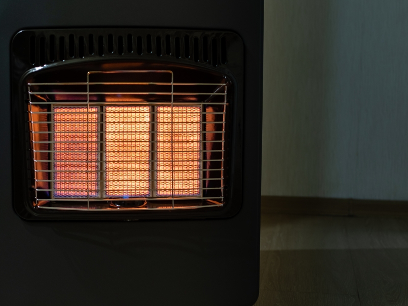 Black gas heater glowing orange needing room heater repair