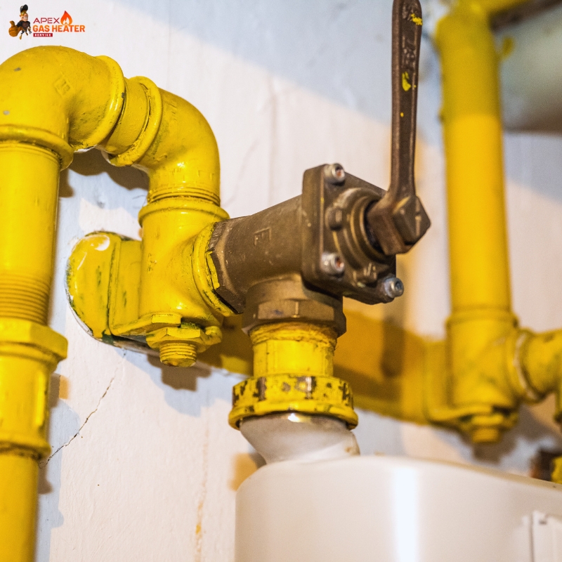 Technician performing Gas Fitting Services with wrench and valve, connecting braided hose to brass pipe on workbench.